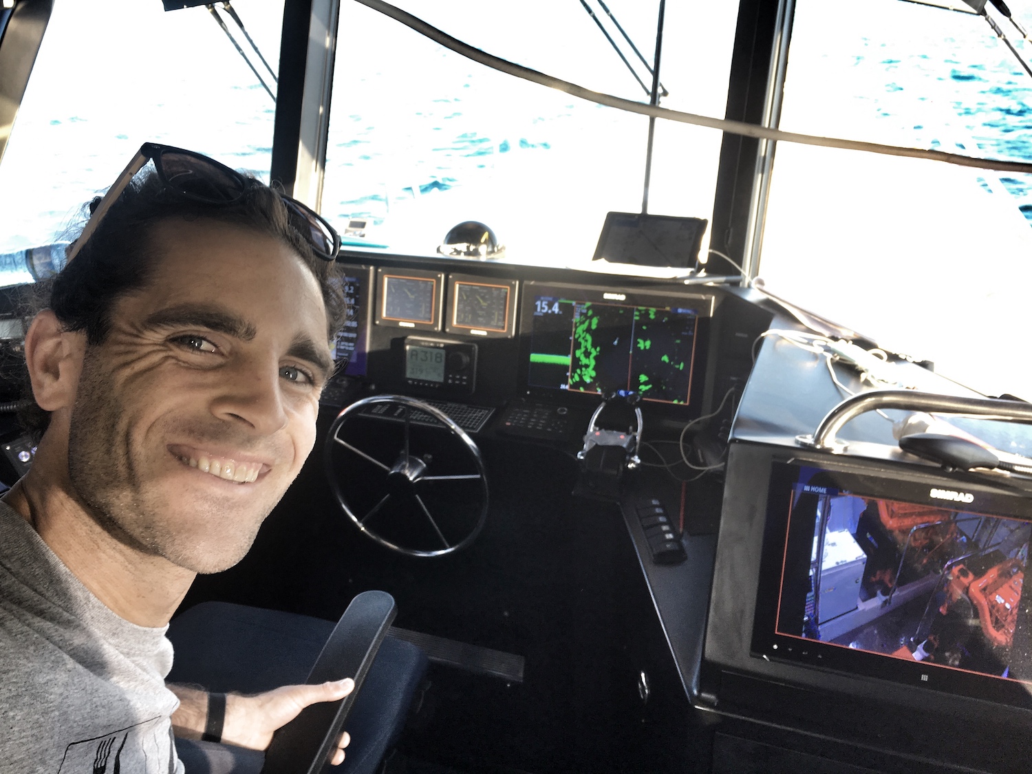 Master at the helm of a pilot boat during a coastal yacht delivery passage through the Great Barrier Reef. 