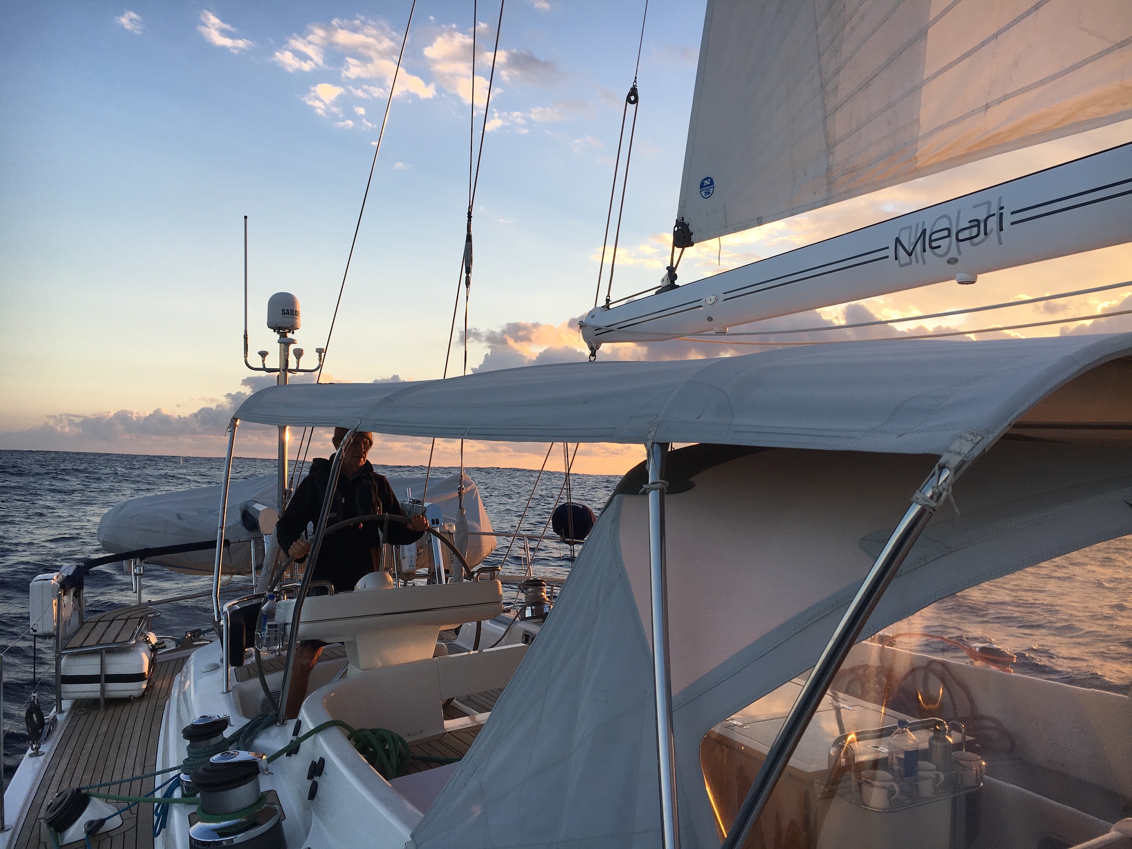 Skipper at the helm of an Oyster 60 sailing yacht underway during an offshore yacht delivery with Salty. 